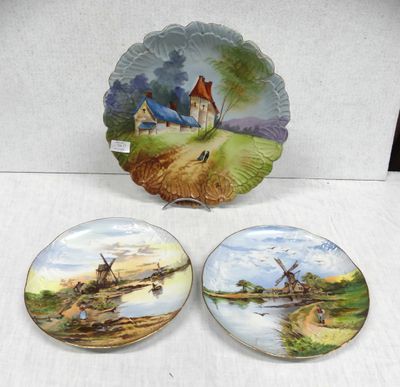 three decorative plates with windmills on them sitting on a table
