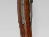 a wooden hand holding a gun on a white background