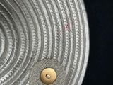 a close up of a metal plate with a button on it