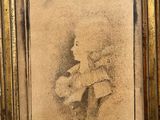 an old picture of a woman holding a teddy bear in a gold frame