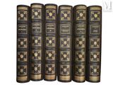 six livres anciens alignés sur un fond blanc