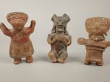 three clay figurines of a man, woman, and child