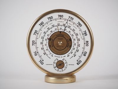 une horloge dorée et blanche posée sur un socle