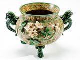 un vase vert orné de fleurs sur fond blanc