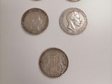 a close up of four different coins on a white surface