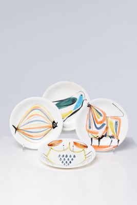 four plates with different designs on them on a white surface