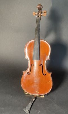 an old violin sitting on top of a wooden stand