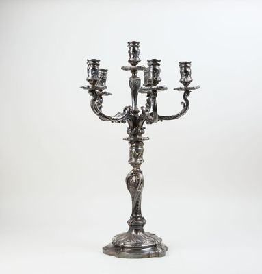 an antique silver candelabra with five candles on a stand