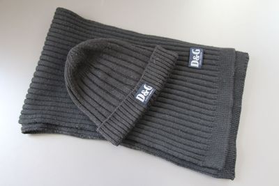 grey knitted beanie and scarf laying on a white surface