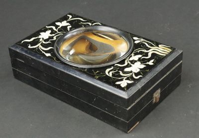 une petite boîte noire contenant un verre