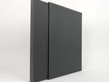 un gros plan d'un livre noir sur fond blanc