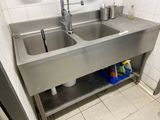 deux éviers dans la cuisine avec une étagère en métal