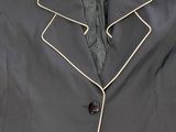 an image of a black jacket with white pips hanging on a hanger