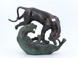 statue représentant un chat et un chien posés sur un rocher, sur fond blanc