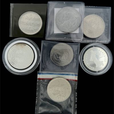 quatre types différents de pièces d'argent dans des sachets en plastique posés sur une surface noire