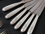 a lot of silverware on a table with forks and spoons