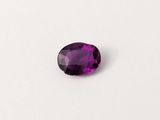 gros plan d'une pierre précieuse violette sur une surface blanche