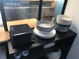 many plates and bowls on a shelf in a kitchen