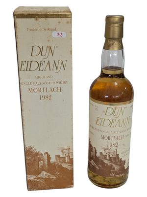 une vieille bouteille de whisky posée à côté d'une boîte en carton