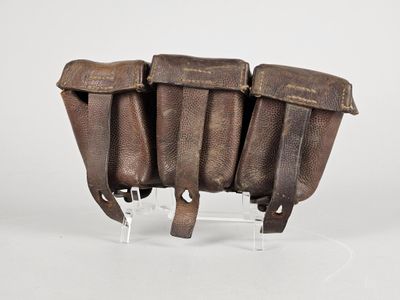 une vieille paire d'étuis en cuir posée sur un socle en acrylique transparent