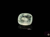 a close up of a green and white diamond on a black surface