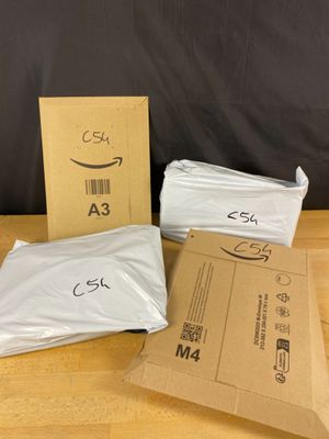 three boxes of amazon boxes sitting on top of a wooden table