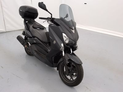 un scooter noir garé dans une pièce aux murs blancs