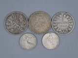six pièces de monnaie britanniques différentes sont disposées en rangée sur un fond bleu