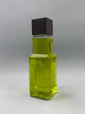 perfume bottle with green liquid on a white background