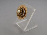 a close up of a ring on a clear stand on a table