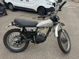 a small motorcycle parked in a parking lot next to a van