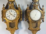 pair of antique clocks on a wall with roman numerals on each of them