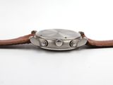 a close up of a watch on a white surface with a brown strap