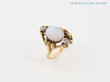 a close up of a ring with an oplite and diamonds on it