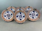 six assiettes chinoises ornées de motifs floraux et d'une bordure dorée
