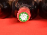 several bottles of wine are lined up on a red surface