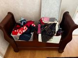 a wooden bench with a bunch of clothes on it