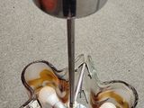 a metal stand with a bowl and spoons on it