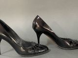 pair of women ' s black pumps on a grey background