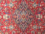 a red rug with a medallion design on it