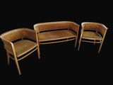 trois chaises en bois et un banc dans une pièce sombre
