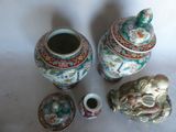 three vases and a small bowl sitting on a table
