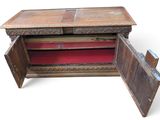 an old wooden cabinet with a red cloth inside of it