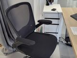 a black office chair sitting in front of a computer desk
