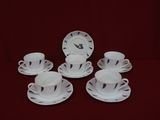 quatre tasses et soucoupes posées sur une table recouverte d'une nappe rouge