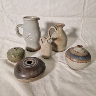 many different types of vases sitting on a table