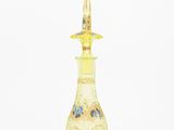 yellow glass perfume bottle with floral decoration on top of it