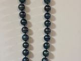a close up of a necklace on a table with a white background