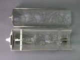a clear glass case with a silver handle on a gray surface