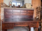 a wooden desk with drawers and a mirror on top of it